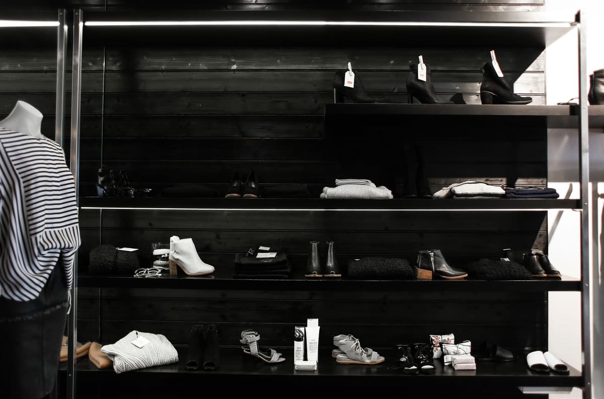 Interior da DM Moda com bolsas, cintos e calçados expostos